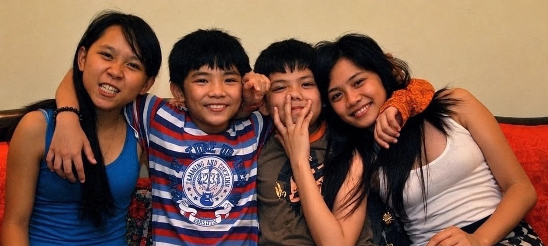 Master Judith’s four children seated together on a couch in 2012